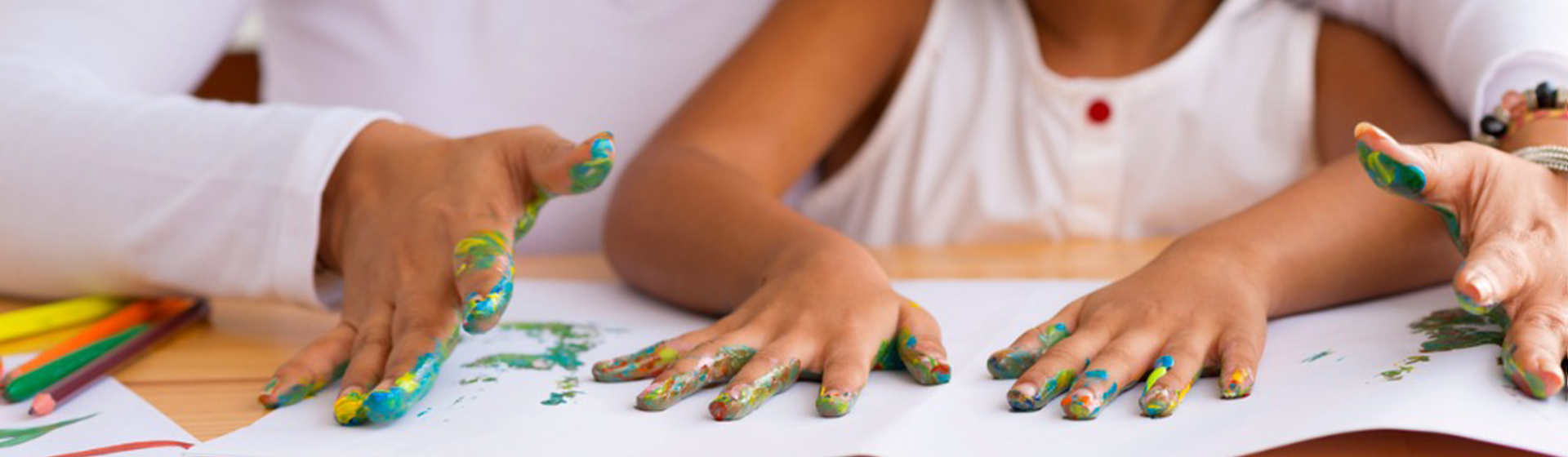 Banner com criança e adulto com as mãos sujas de tintas fazendo atividades